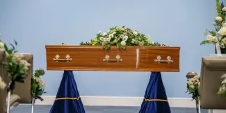 Close up image of a wooden coffin in a funeral service