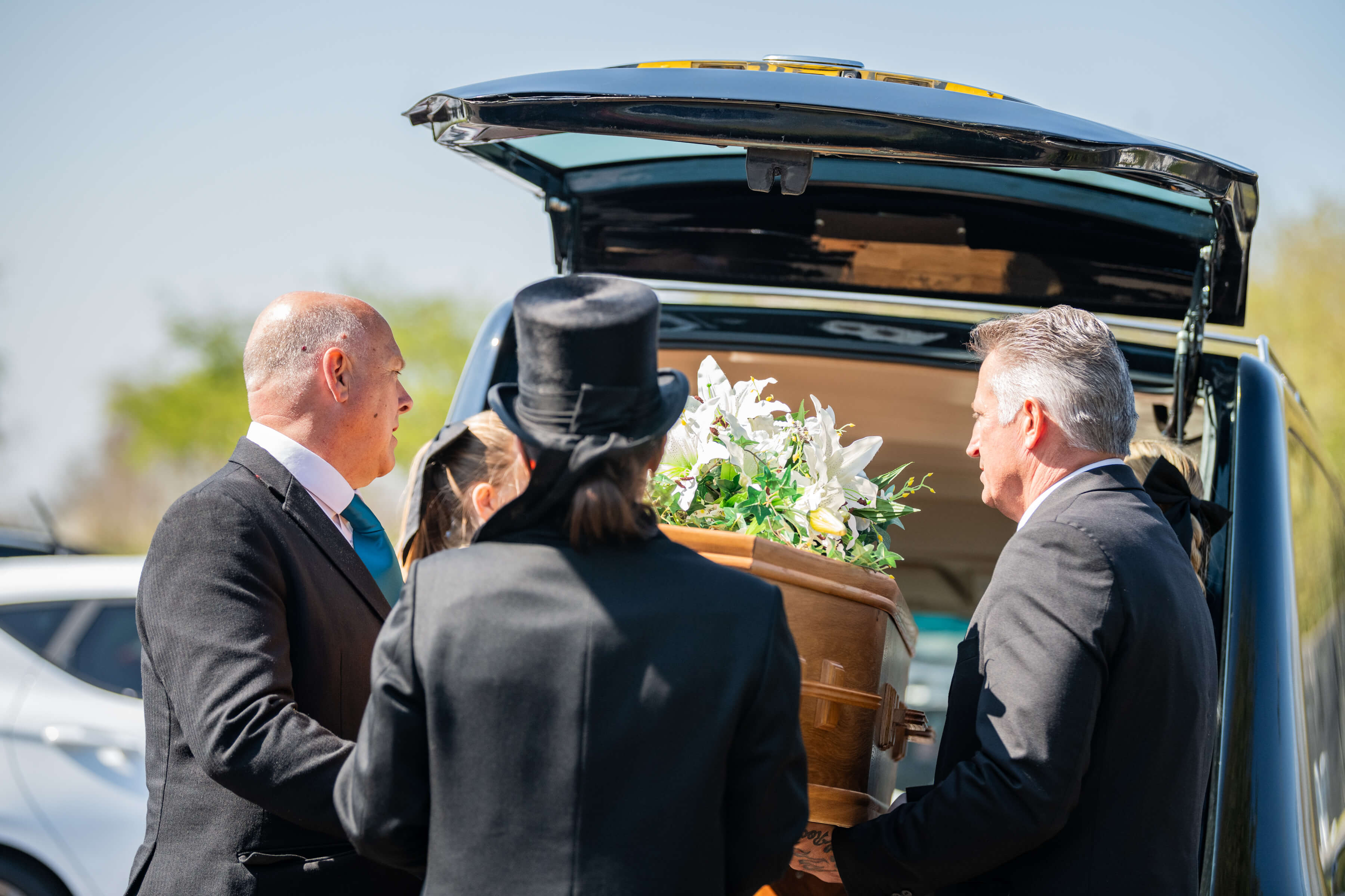 Funeral Directors Loading a coffin into a Hearse